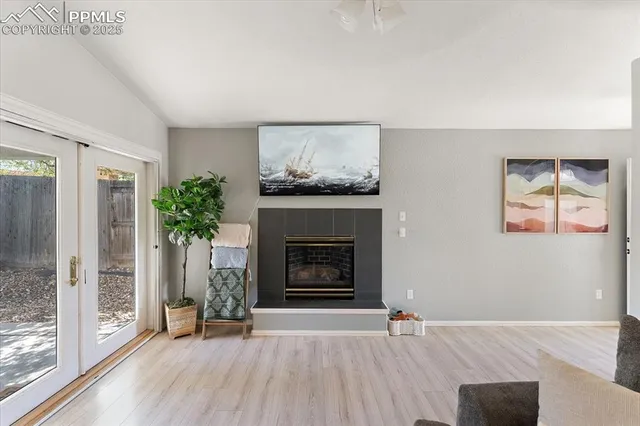 an empty room with windows and fireplace