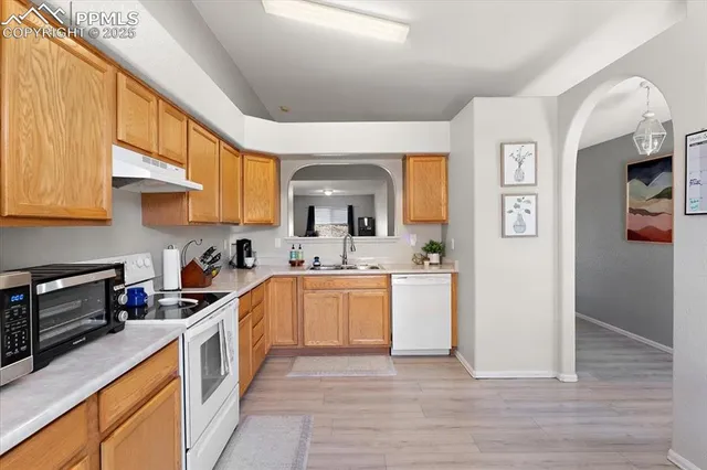 a kitchen with a sink cabinets and wooden floor
