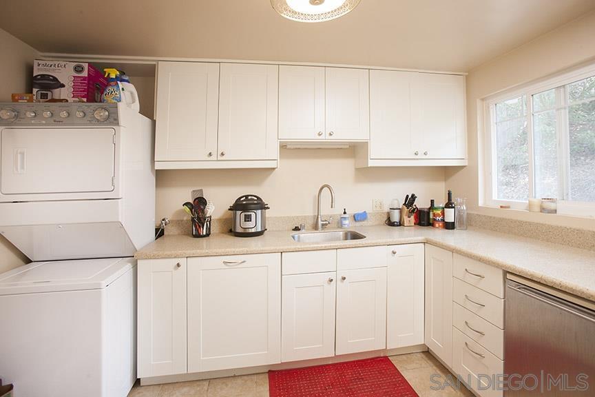 329 9th Street Del Mar, CA 92014 - Photo 23 of 29 a kitchen with white cabinets sink and window