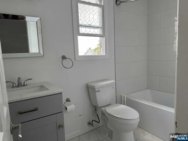a bathroom with a granite countertop toilet a sink and mirror