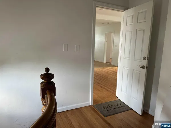 a view of a hallway with entryway wooden floor and front door