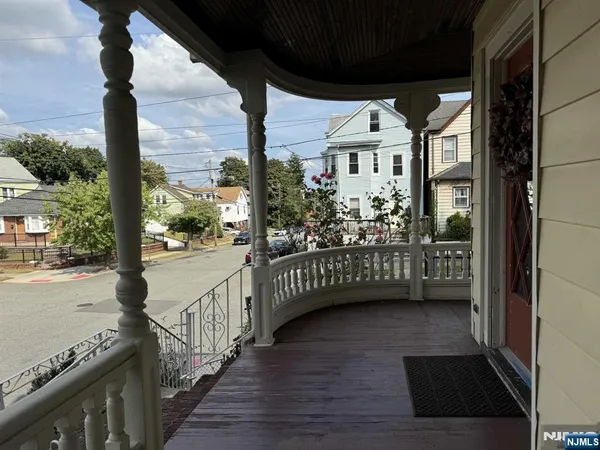 a view of a porch with wooden floor and iron stairs