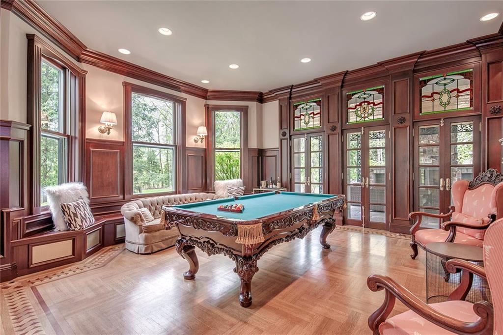 404 Beaver Road Sewickley, PA 15143 - Photo 3 of 24 Cherry paneled Billiards room with hidden TV and cabinets accessing the veranda and outside fireplace.