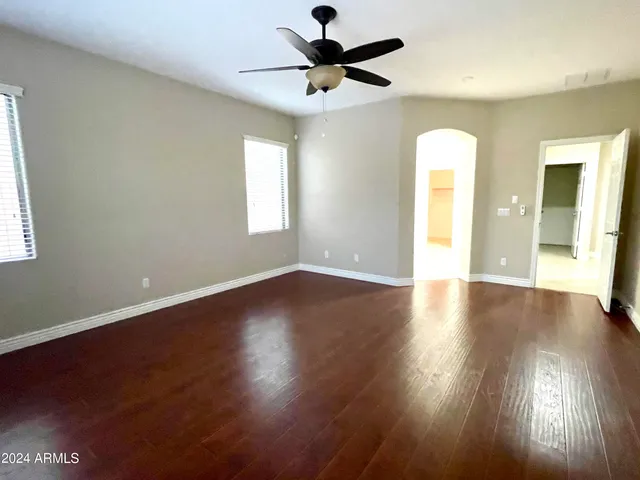 a view of an empty room with window and wooden floor