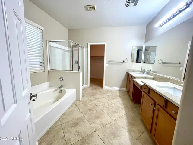 a spacious bathroom with a tub sink and mirror