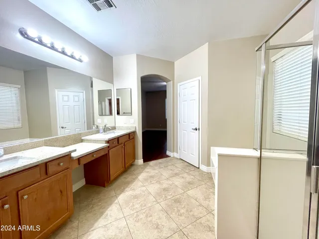 a large bathroom with a large mirror vanity and shower