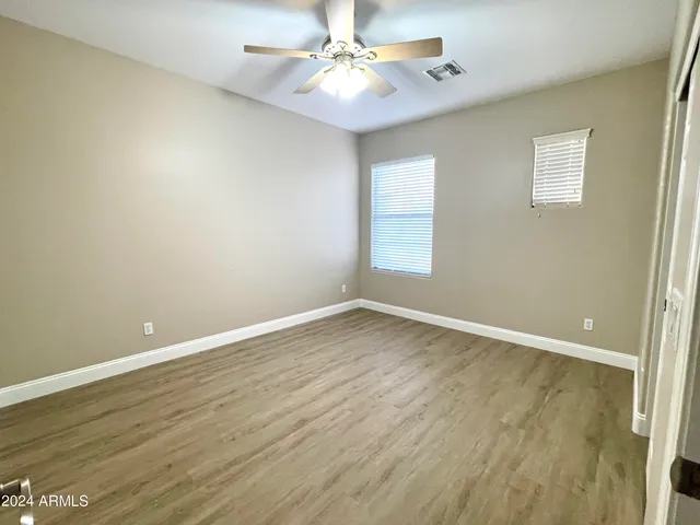 an empty room with a window and wooden floor