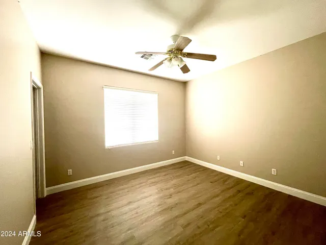 a view of a room with wooden floor and fan