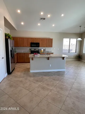 a large kitchen with stainless steel appliances a stove a sink a microwave and a refrigerator