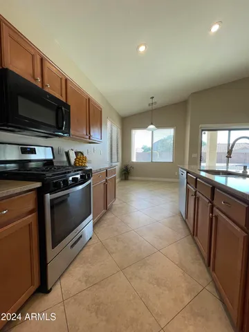 a kitchen with stainless steel appliances granite countertop a stove a sink and a microwave