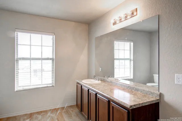 a bathroom with a granite countertop sink and window