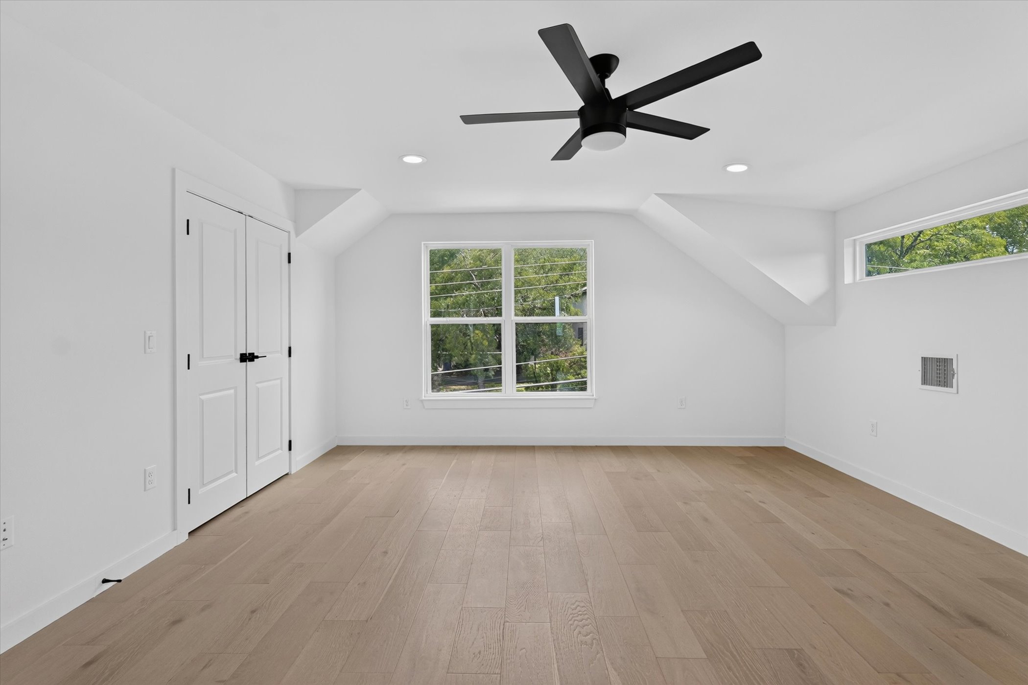 5305 Ledesma Road, Unit 1 Austin, TX 78721 - Photo 35 of 37 An airy upper-level room showcases sloped ceilings and light wood floors.