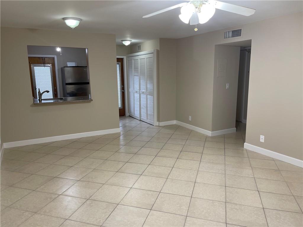 550 Southeast 2nd Avenue, Unit G5 Deerfield Beach, FL 33441 - Photo 15 of 28 an empty room with kitchen and chandelier fan