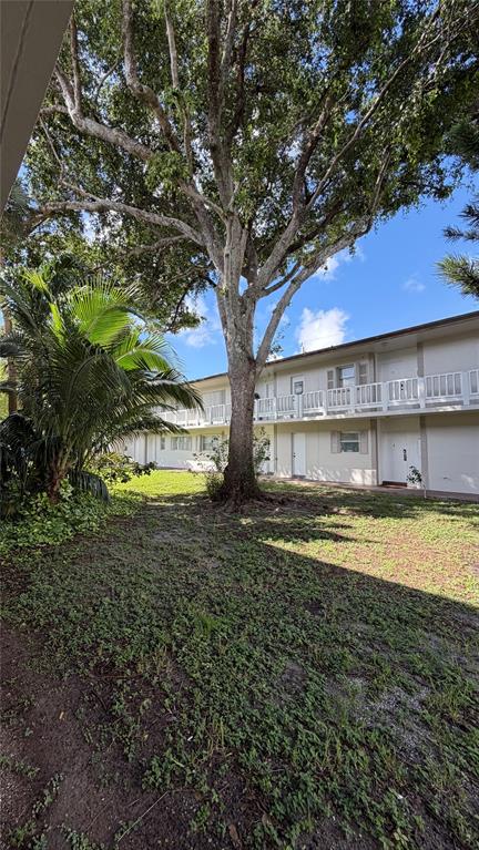 550 Southeast 2nd Avenue, Unit G5 Deerfield Beach, FL 33441 - Photo 24 of 28 a view of a house with a yard and a large tree