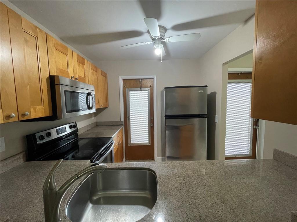 550 Southeast 2nd Avenue, Unit G5 Deerfield Beach, FL 33441 - Photo 5 of 28 a kitchen with stainless steel appliances granite countertop a refrigerator stove and microwave
