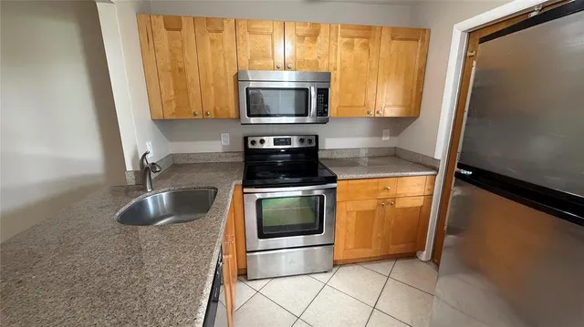 a kitchen with granite countertop a stove and a microwave