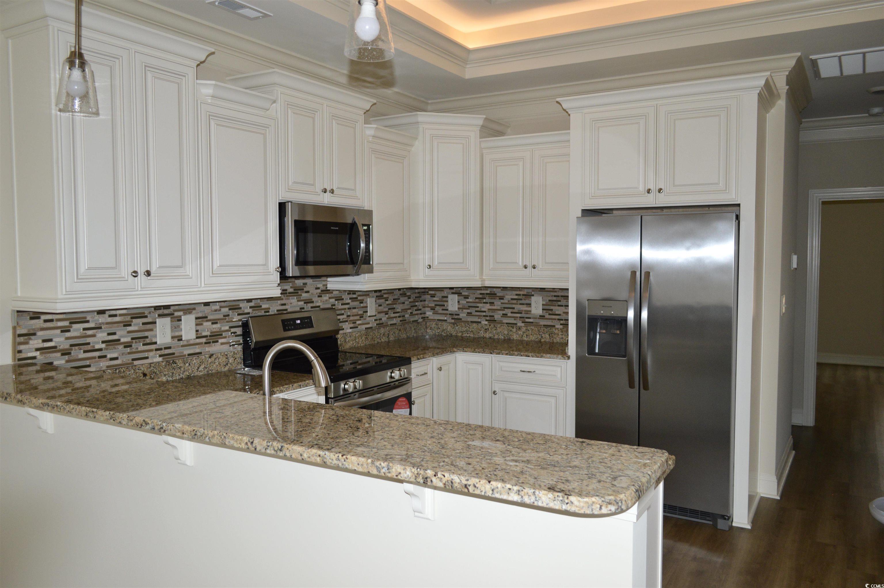 110 Hallandale Lane Murrells Inlet, SC 29576 - Photo 8 of 37 Kitchen featuring kitchen peninsula, granite countertops, backsplash, and stainless steel appliances
