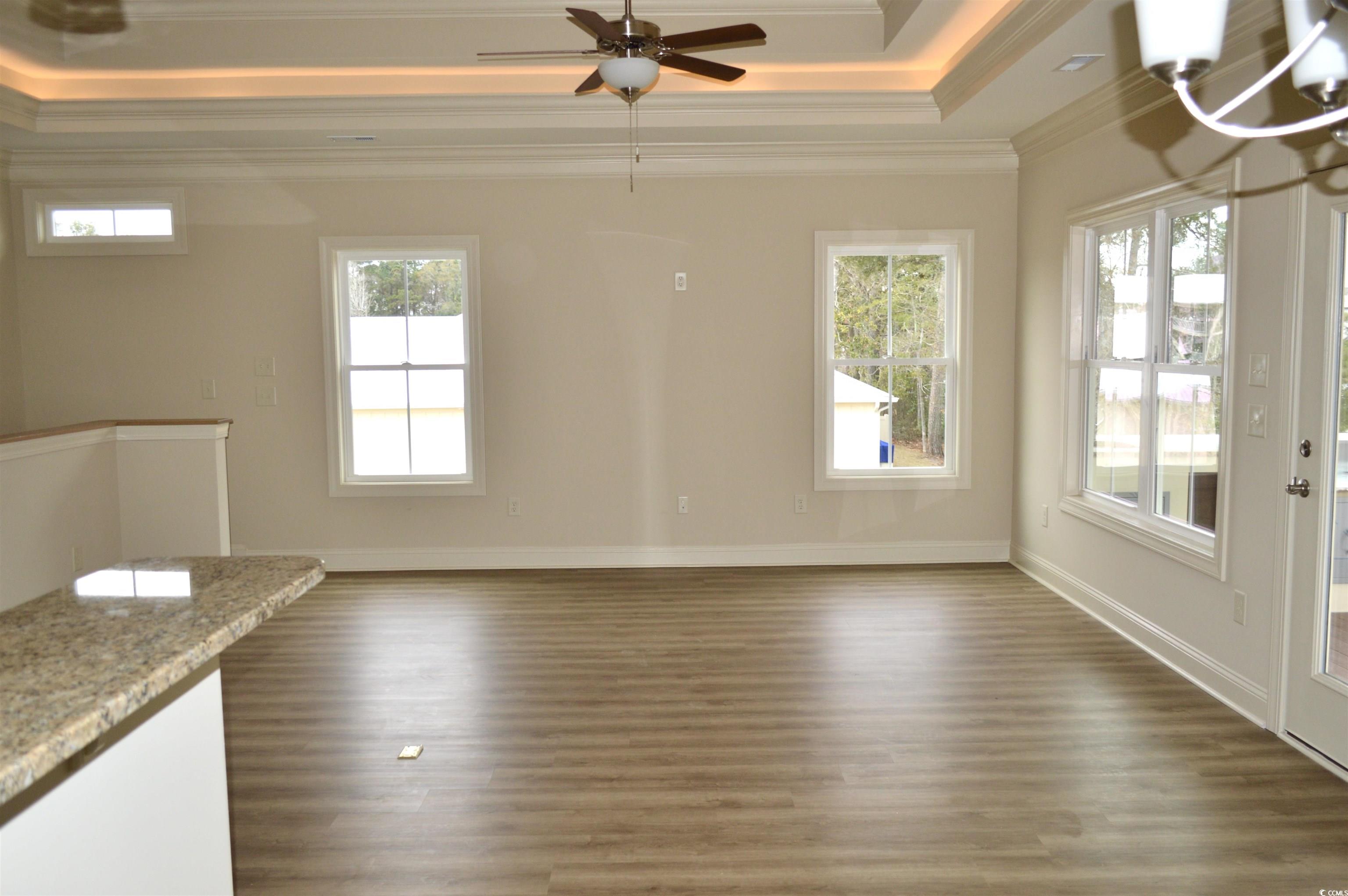 110 Hallandale Lane Murrells Inlet, SC 29576 - Photo 10 of 37 Living dining area with a tray ceiling, a wealth of natural light, and crown molding