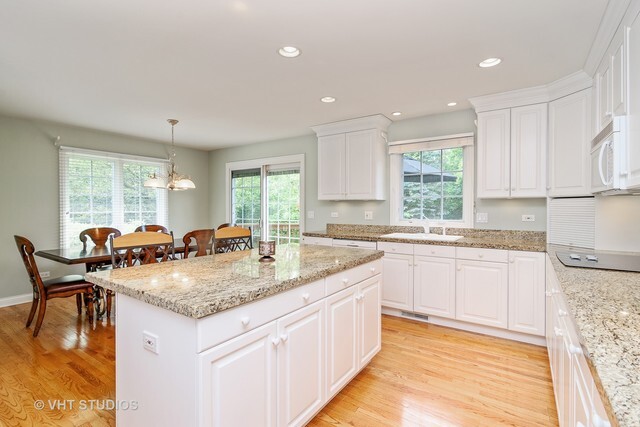20 Lochbrook Lane Inverness, IL 60010 - Photo 6 of 27 a kitchen with granite countertop sink stove and white cabinets with wooden floor