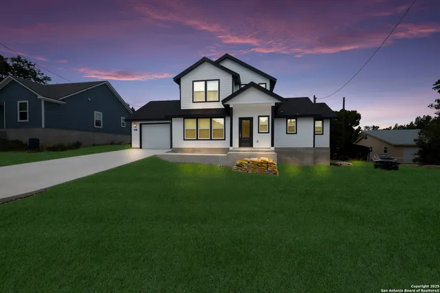 a front view of a house with a yard and trees