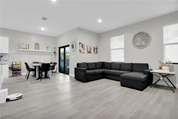 a view of living room kitchen with stainless steel appliances cabinets