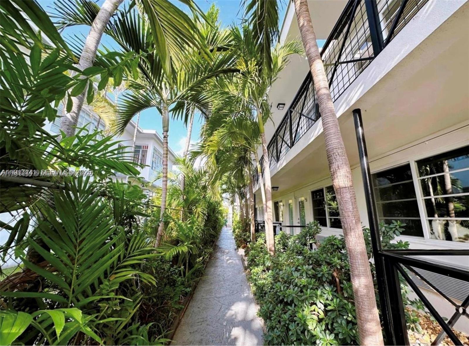 7315 Byron Avenue, Unit 8 Miami Beach, FL 33141 - Photo 1 of 13 a view of a pathway that has a couple of flower plants
