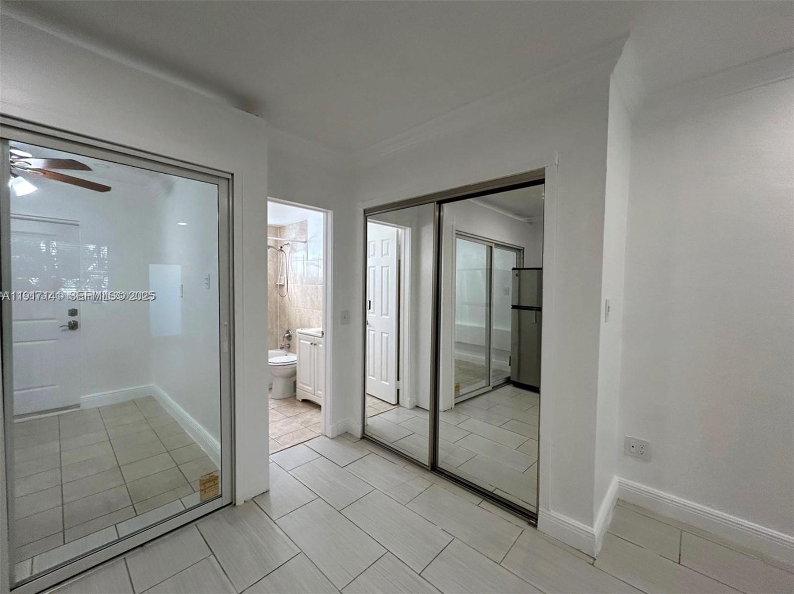 7315 Byron Avenue, Unit 8 Miami Beach, FL 33141 - Photo 7 of 13 a bathroom with a glass shower door and a glass door