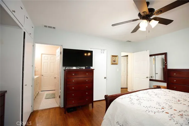 a bedroom with a bed and a flat tv screen on dresser
