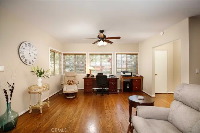 a living room with furniture floor to ceiling window and a wooden floor