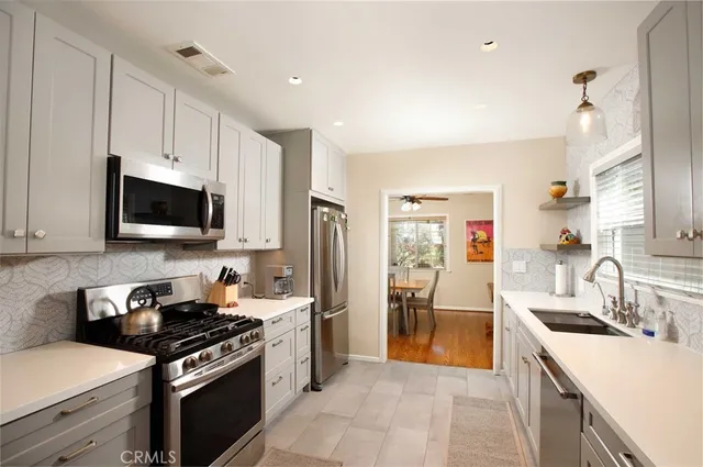 a kitchen with stainless steel appliances granite countertop a sink stove and refrigerator