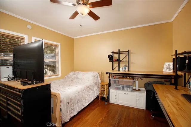 a bedroom with a bed and a flat tv screen on the dresser