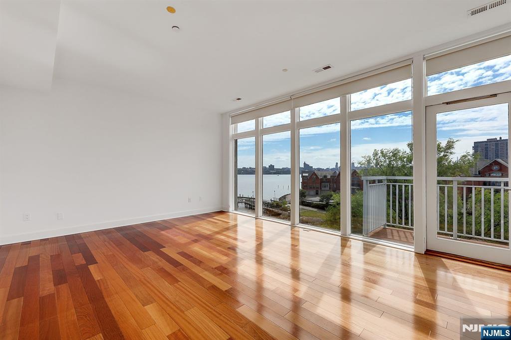 22 Vela Way Edgewater, NJ 07020 - Photo 15 of 43 a view of an empty room with wooden floor and a window
