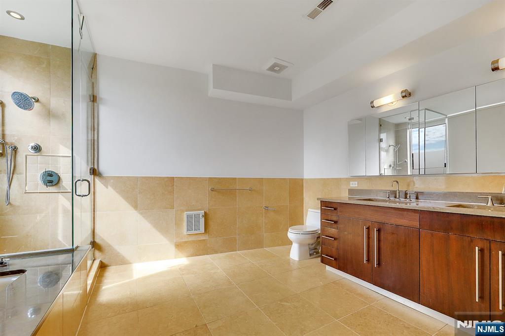 22 Vela Way Edgewater, NJ 07020 - Photo 18 of 43 a spacious bathroom with a double vanity sink a toilet and a bathtub