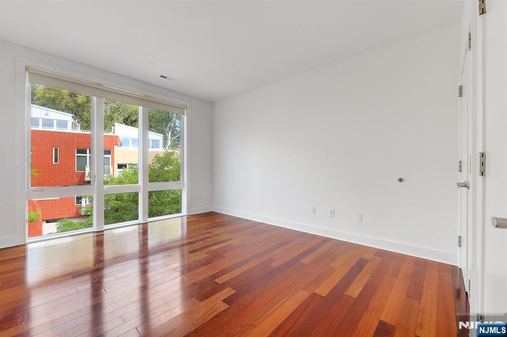 22 Vela Way Edgewater, NJ 07020 - Photo 19 of 43 a view of an empty room with wooden floor and a window