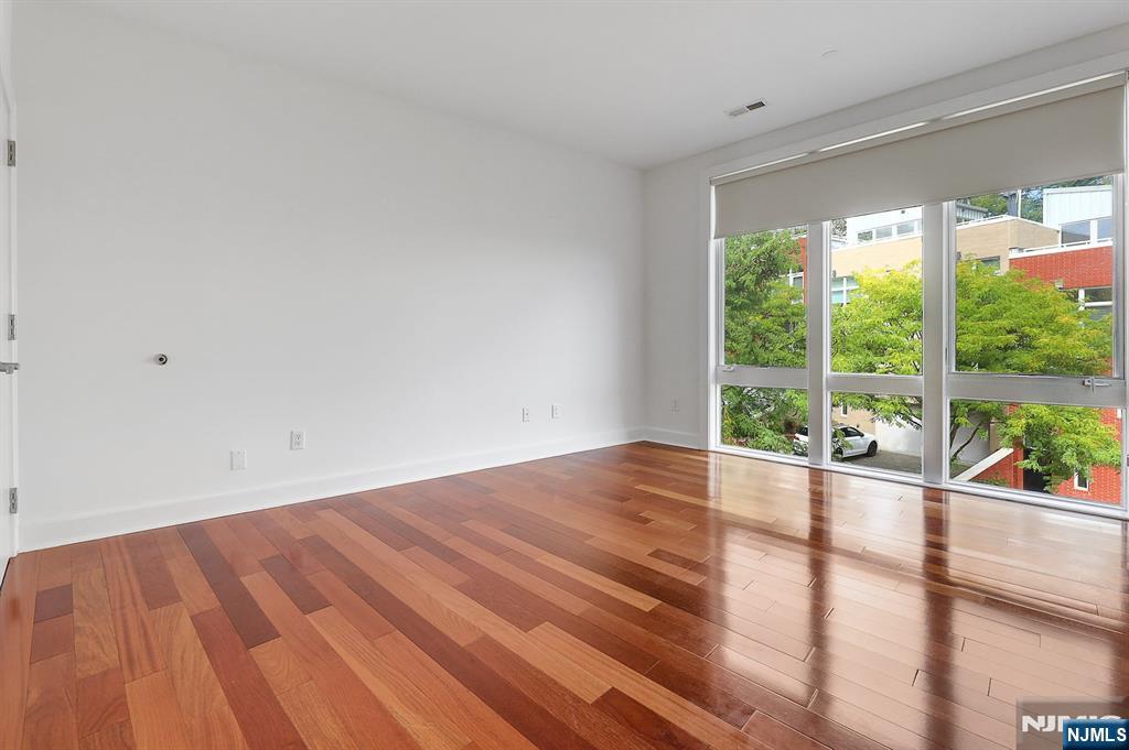 22 Vela Way Edgewater, NJ 07020 - Photo 23 of 43 a view of an empty room with wooden floor and a window