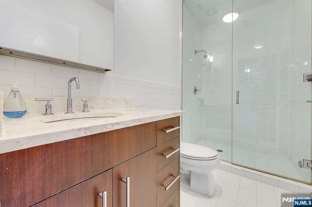 22 Vela Way Edgewater, NJ 07020 - Photo 30 of 43 a bathroom with a sink a toilet and shower