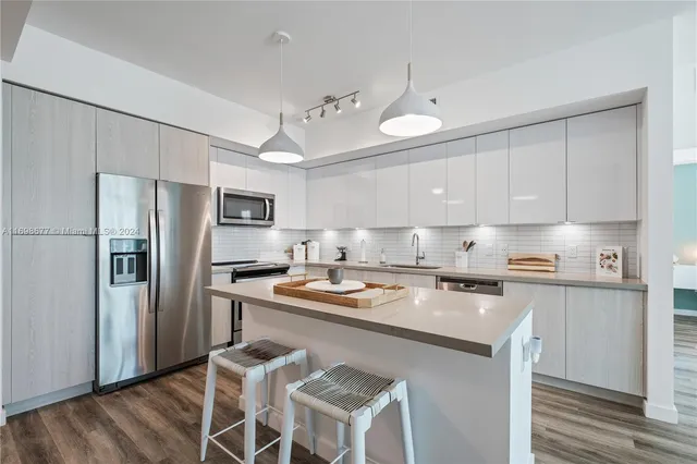 a kitchen with stainless steel appliances granite countertop a sink a stove a microwave and wooden cabinets