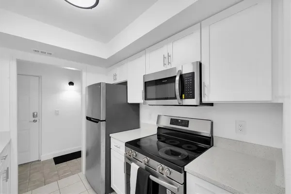 a kitchen with stainless steel appliances a refrigerator stove and microwave