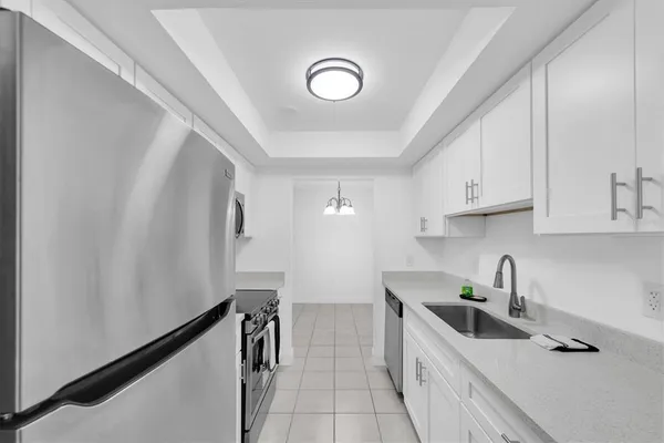 a kitchen with white cabinets a sink and dishwasher