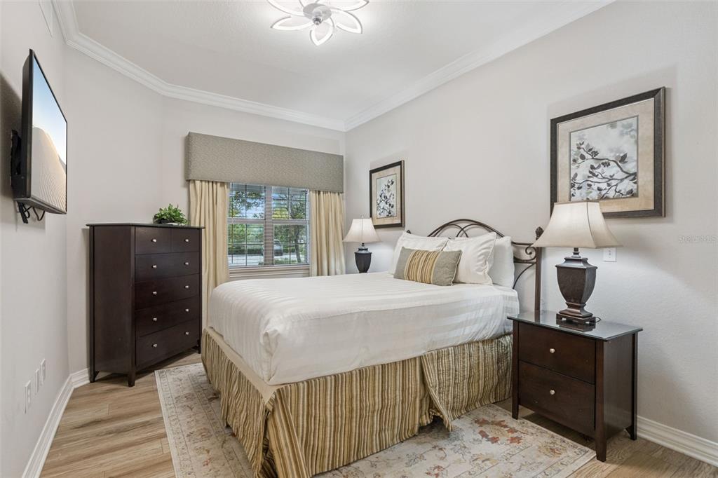 1100 Sunset View Circle, Unit 102 Reunion, FL 34747 - Photo 12 of 67 a bedroom with a bed and a flat tv screen on dresser