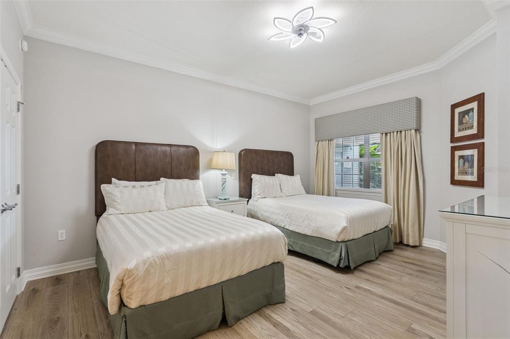 1100 Sunset View Circle, Unit 102 Reunion, FL 34747 - Photo 14 of 67 a bedroom with two beds and a chandelier