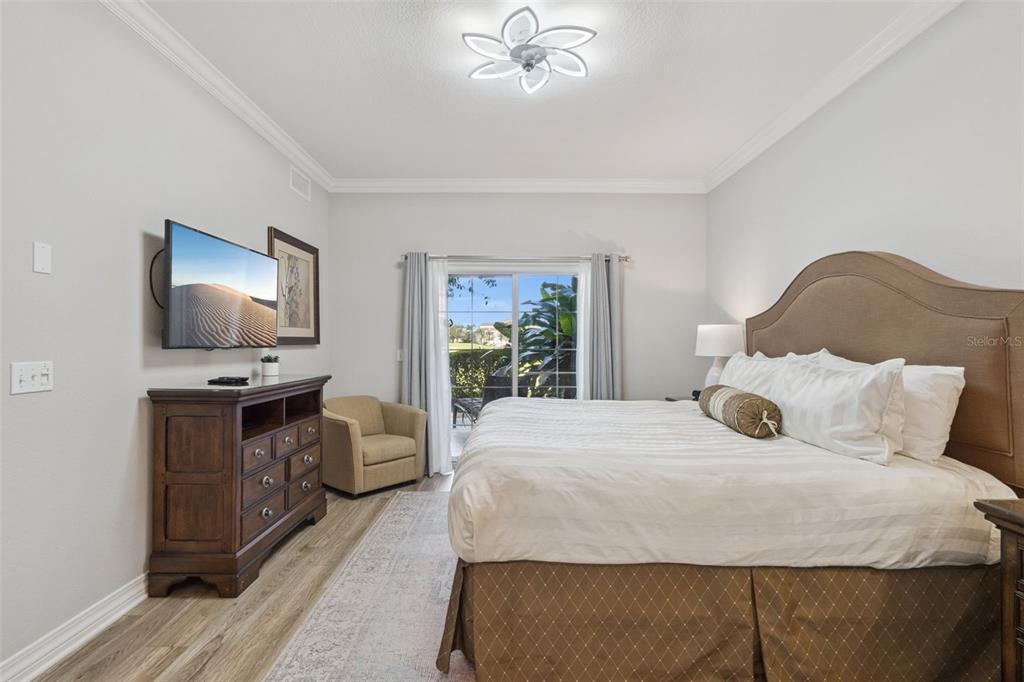 1100 Sunset View Circle, Unit 102 Reunion, FL 34747 - Photo 15 of 67 a bedroom with a large bed and a tv