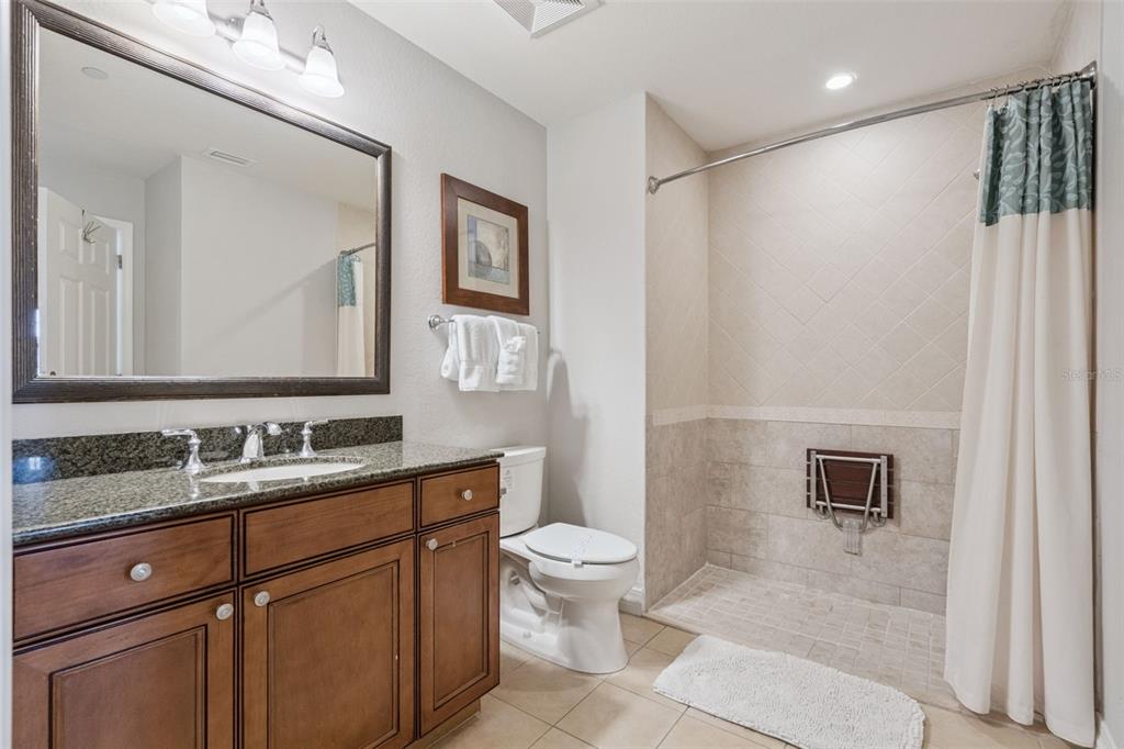 1100 Sunset View Circle, Unit 102 Reunion, FL 34747 - Photo 17 of 67 a bathroom with a toilet a sink a mirror a vanity and mirror