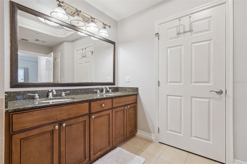 1100 Sunset View Circle, Unit 102 Reunion, FL 34747 - Photo 27 of 67 a bathroom with a double vanity sink and a mirror