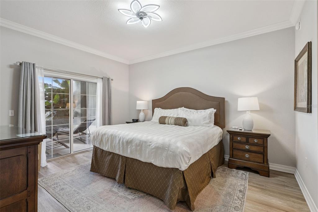 1100 Sunset View Circle, Unit 102 Reunion, FL 34747 - Photo 28 of 67 a large bed sitting in a bedroom next to a window with a lamp and a large mirror