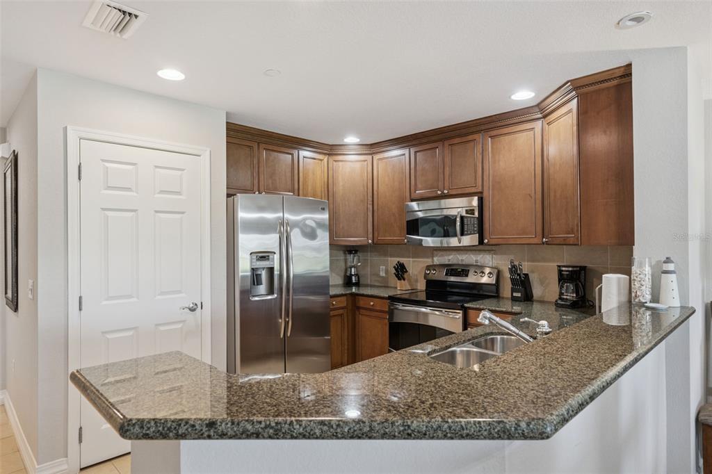 1100 Sunset View Circle, Unit 102 Reunion, FL 34747 - Photo 7 of 67 a kitchen with kitchen island granite countertop a sink a stove and refrigerator