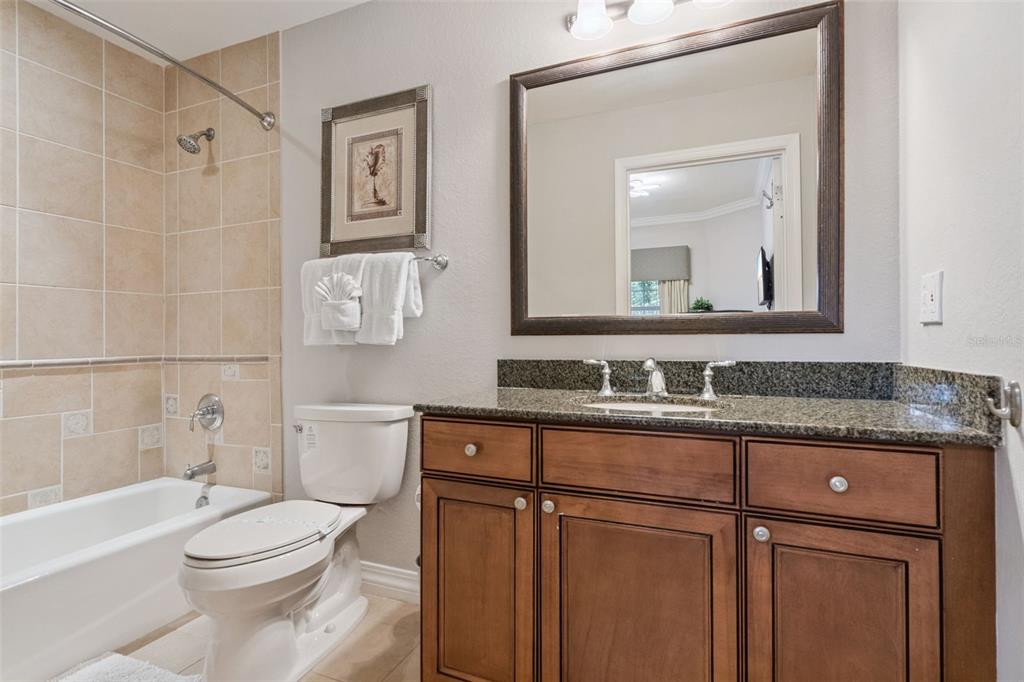 1100 Sunset View Circle, Unit 102 Reunion, FL 34747 - Photo 10 of 67 a bathroom with a granite countertop toilet sink and mirror