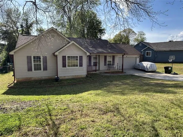 a view of a yard in front of a house with large tree