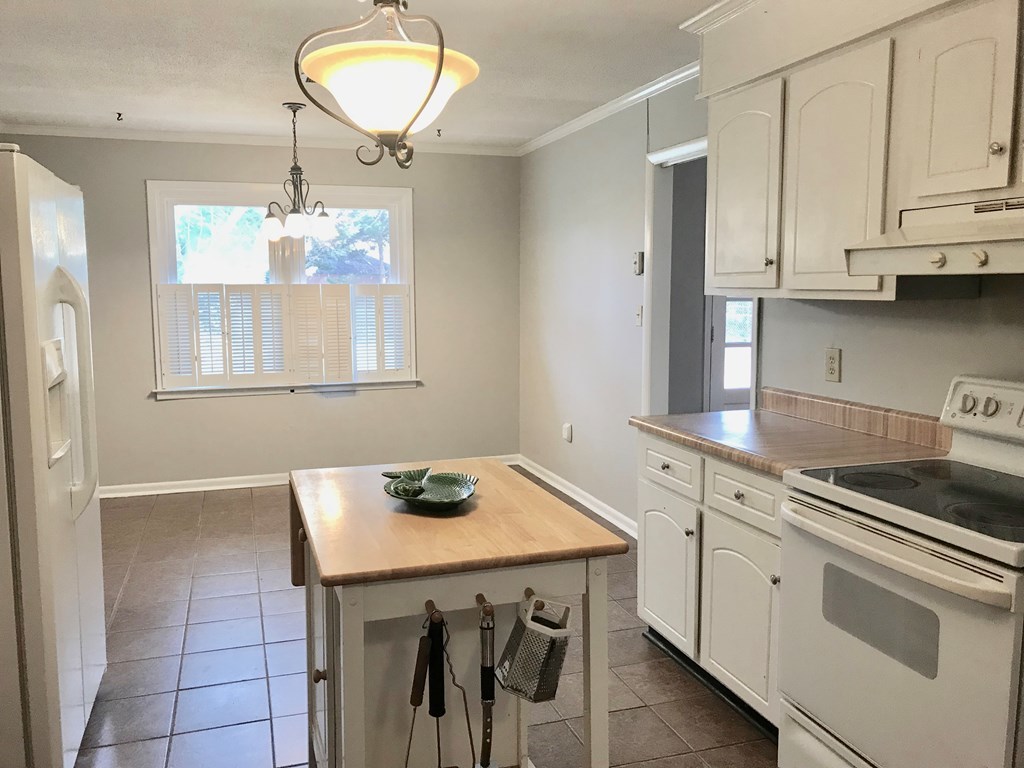 102 Valley Ridge Drive Perry, GA 31069 - Photo 8 of 25 a kitchen with a table chairs and white cabinets