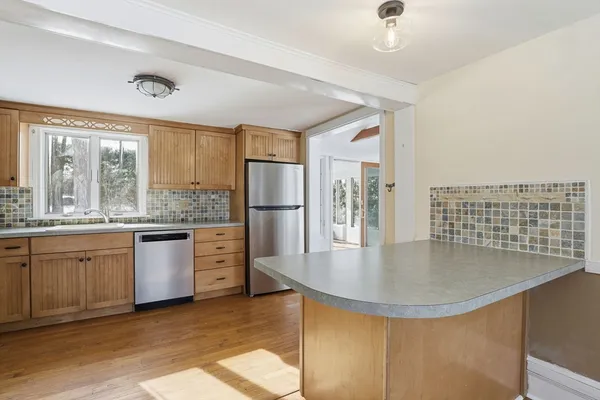 a kitchen with sink refrigerator and large window